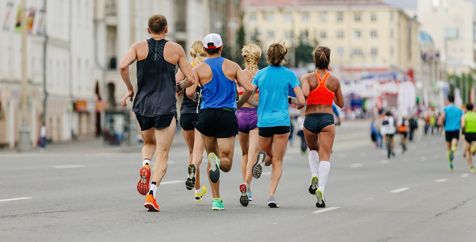 A pack of marathon runners holding even pace together on a city course